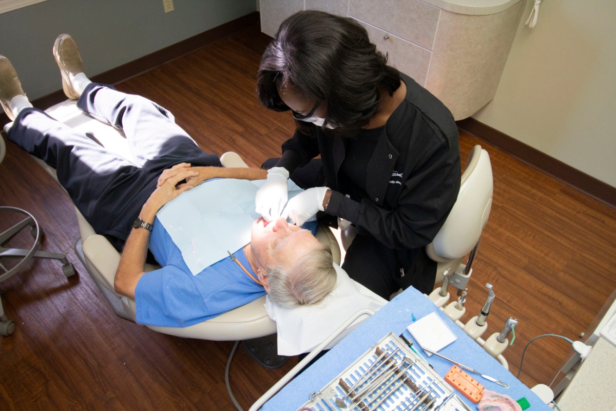 Dental assistant at Scott Edwards DDS cleaning a patient's teeth